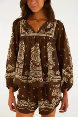 Blusa marrón de manga larga con estampado de estilo bandana en color crudo, escote en V con cordones y silueta amplia de corte bohemio.