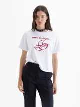 Remera blanca de manga corta con estampado frontal de dos cerezas con forma de labios y el texto "TYPES OF KISSES" en rojo.