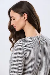 Blusa clásica de manga larga en color blanco, con cuello redondo y diseño fluido.