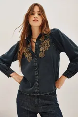 Camisa de liocel color gris oscuro con bordado de flores negras en las mangas largas abullonadas.