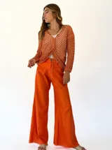 Pantalón de lino color naranja, de corte palazzo y tiro alto.