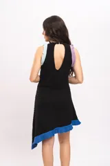 Vestido corto de punto negro con diseño asimétrico, sin mangas, con detalles de volados en tonos lila, celeste y azul en los tirantes y el borde inferior.