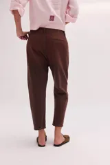 Pantalón de jean de tiro bajo y calce relajado, con cierre frontal de múltiples botones visibles y largo al tobillo.