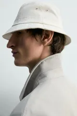 Cazadora de corte relajado confeccionada en tejido de algodón compacto con efecto lavado. Presenta cuello de solapa, manga larga con puños abotonados y cierre frontal de botones. Incluye cuatro bolsillos frontales: dos de plastrón con solapa en el pecho y dos bolsillos dobles de plastrón en la cadera.