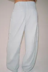 Pantalón cargo de tiro medio, confeccionado en mezcla de algodón y lino, con perneras anchas, bolsillos de plastrón en el delantero y cierre frontal con cremallera y botón.