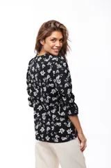 Blusa negra con estampado floral blanco, escote en V y mangas 3/4 con volados.