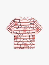 Remera Tommy Hilfiger de corte regular confeccionada en puro algodón con punto interlock. Presenta un diseño de rayas horizontales rojas y blancas con estampado floral gráfico superpuesto, cuello redondo y mangas cortas.