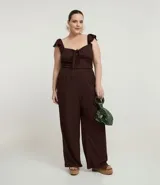 Pantalón de tiro alto, corte flare (acampanado), color marrón oscuro, confeccionado en tejido texturizado anarruga con cintura elástica.