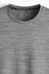 Remera deportiva gris melange con tecnología DryMove™, de manga corta y cuello redondo, diseñada con tejido de malla transpirable y elástico para entrenar.
