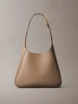 Cartera tipo hobo mediana Calvin Klein de poliuretano color beige, con diseño estructurado, costuras pespunteadas y correa ajustable con hebilla metálica dorada.
