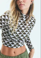 Polera verde con estampado de monogramas, de lycra con poliamida, cuello alto y mangas largas.