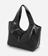 Cartera shopper grande Satinato de poliuretano color negro, con acabado texturizado brillante, diseño amplio y asa de hombro ancha.