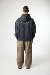 Hoodie de corte oversize color gris oscuro, con capucha, bolsillo frontal tipo canguro y logo pequeño bordado en el centro del pecho.