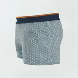 Pack de tres boxers de algodón elastizado, uno liso color celeste, uno con estampado geométrico azul oscuro sobre celeste y otro con estampado geométrico celeste sobre blanco. Todos tienen cintura elástica con logo de la marca.