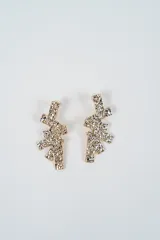 Aros colgantes con diseño abstracto compuesto por piezas rectangulares superpuestas con textura rugosa y acabado metálico brillante.