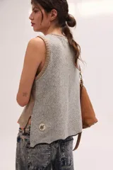 Chaleco de punto de lambswool color mostaza, sin mangas, con cuello redondo y diseño de ochos en la parte delantera.
