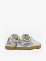 Championes Veja modelo Volley, con acabado metalizado plateado, suela de goma color caramelo y detalle de la V lateral en color blanco.