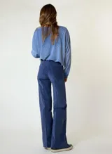 Pantalón de corte recto y tiro medio, confeccionado en pana color bordó. Presenta costuras verticales decorativas en el frente, cierre con botón y bolsillos laterales.