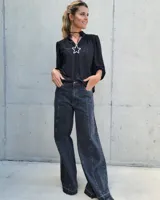 Pantalón de jean estilo wide leg con costuras verticales frontales, tiro alto y bolsillos laterales.