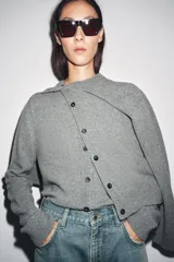 Chaqueta de tejido de punto color verde musgo, de corte cropped, con cuello redondo y cierre frontal de botones oscuros.