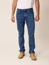 Pantalón de jean corte recto en color azul medio, con cierre de botón y cremallera, y bolsillos laterales y traseros.