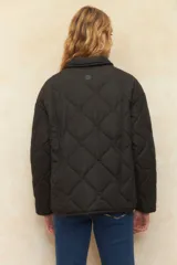 Campera capitoneada negra con botones veteados, bolsillos laterales de solapa y forro de satén con estampado animal print.