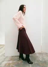Falda midi plisada de color bordó, con diseño de corte evasé y cintura alta.