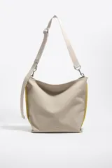 Bolso bandolera Bimba y Lola modelo Carlino, de tamaño mediano, color beige con detalles en amarillo y correa ajustable.