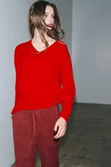 Jersey de manga larga confeccionado en hilatura de lana 100%, con escote en pico y acabado de punto fino.