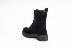 Bota de caña media confeccionada en gamuza negra, con sistema de acordonado frontal mediante ojales metálicos dorados y suela de goma dentada tipo track.