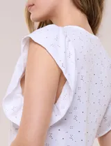 Blusa blanca de tejido calado estilo broderie con escote en V y mangas cortas tipo mariposa.
