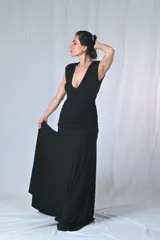 Vestido largo negro con escote en V profundo y bordado con lentejuelas en el escote. Corte ajustado en la cintura y falda larga con caída fluida.