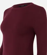Suéter de punto ajustado color crema, con cuello redondo, manga larga y detalle de botones metalizados en los puños.