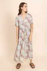 Vestido largo con estampado de hojas en tonos verde, rojo y blanco, con escote en V y botones frontales.