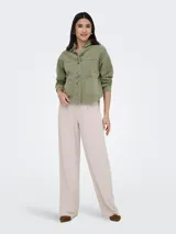 Sobrecamisa de jean de color negro gastado, con cuello camisero, cierre frontal de botones metálicos, bolsillos frontales de parche y mangas largas.