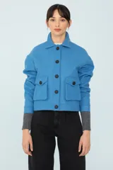 Chaqueta azul con bolsillos delanteros forrada, botones metálicos y cuello desmontable con corderito.
