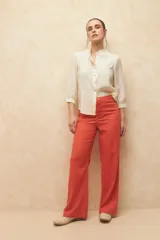 Pantalón de lino color verde, de tiro alto, con bolsillos en el frente y atrás, y corte recto.