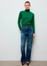 Sweater de punto fino color verde, de manga larga y cuello vuelto, con diseño ajustado al cuerpo.
