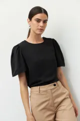 Top negro de mangas cortas abullonadas, con botones forrados en la misma tela.