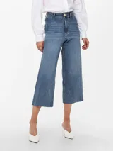 Jean de corte wide leg y tiro alto, con diseño cropped y terminación deshilachada en el ruedo. Confeccionado en denim elástico con cinco bolsillos y cierre frontal con botón metálico.