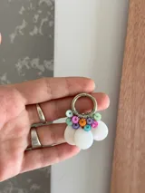 Aro colgante plateado con cuentas de nácar blancas y cuentas de colores.