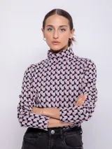 Polera negra con estampado geométrico en blanco, de cuello alto y manga larga.