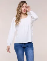 Blusa de modal y elastano color blanco, de silueta holgada, escote redondo amplio con elástico interno fruncido y mangas largas fluidas con puños ajustados.