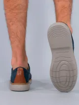 Zapato casual Hush Puppies modelo Bangu, con diseño híbrido que combina cuero en el talón y laterales con tejido técnico transpirable en la puntera y empeine. Cuenta con cordones, suela de EVA flexible y detalle de costura perimetral en tono natural.