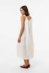 Vestido midi celeste de calce amplio y liviano, con escote fruncido regulable y breteles finos con detalles de cuentas. Presenta una silueta suelta e incluye una mini cartera desmontable al tono.