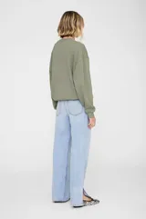 Buzo de corte relajado estilo universitario, confeccionado en algodón fleece color verde oliva. Presenta cuello redondo, mangas largas con puños ajustados y un parche frontal con la palabra 'BING' en letras grandes.