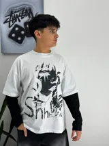 Remera oversize blanca de manga larga, con estampado gráfico en blanco y negro en el frente con la inscripción 'Shhh...'.