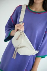 Riñonera color crudo de cuero vacuno con correa regulable y cierre con cremallera.