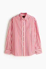Camisa de popelina de algodón con cuello inglés, tapeta clásica, bolsillo frontal aplicado y mangas largas con puños abotonados. Presenta un diseño de rayas verticales en tonos rojos y blancos y un corte relajado.