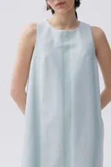 Vestido corto sin mangas de denim liviano a rayas verticales celestes y verdes. Cuenta con cuello redondo, abertura en la espalda y bajo desflecado.